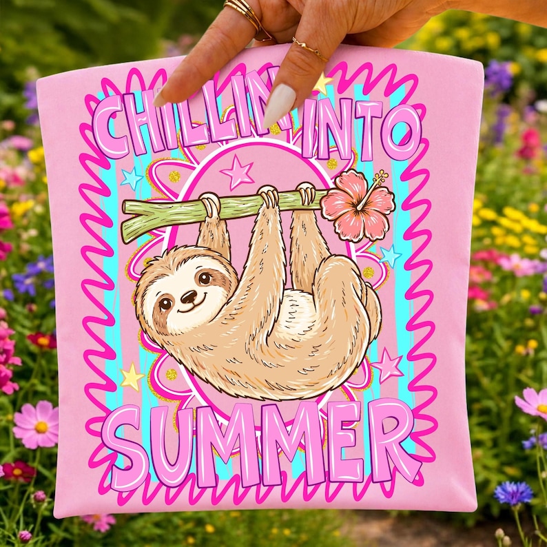Może przedstawiać: R&oacute;żowa koszulka z kresk&oacute;wkowym leniwcem wiszącym na gałęzi z r&oacute;żowym kwiatem hibiskusa. Napis "CHILLIN' INTO SUMMER" jest w kolorze r&oacute;żowym i niebieskim. Projekt otoczony jest gwiazdami i falistą obw&oacute;dką.