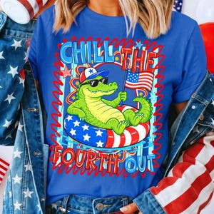 K&ouml;nnte beinhalten: Blaues T-Shirt mit einer Grafik eines Cartoon-Alligators, der eine Sonnenbrille und einen patriotischen Hut tr&auml;gt und in einem rot-wei&szlig;-blauen Schwimmreifen schwimmt. Der Text "Chill the Fourth Out" ist in Rot und Blau dargestellt.