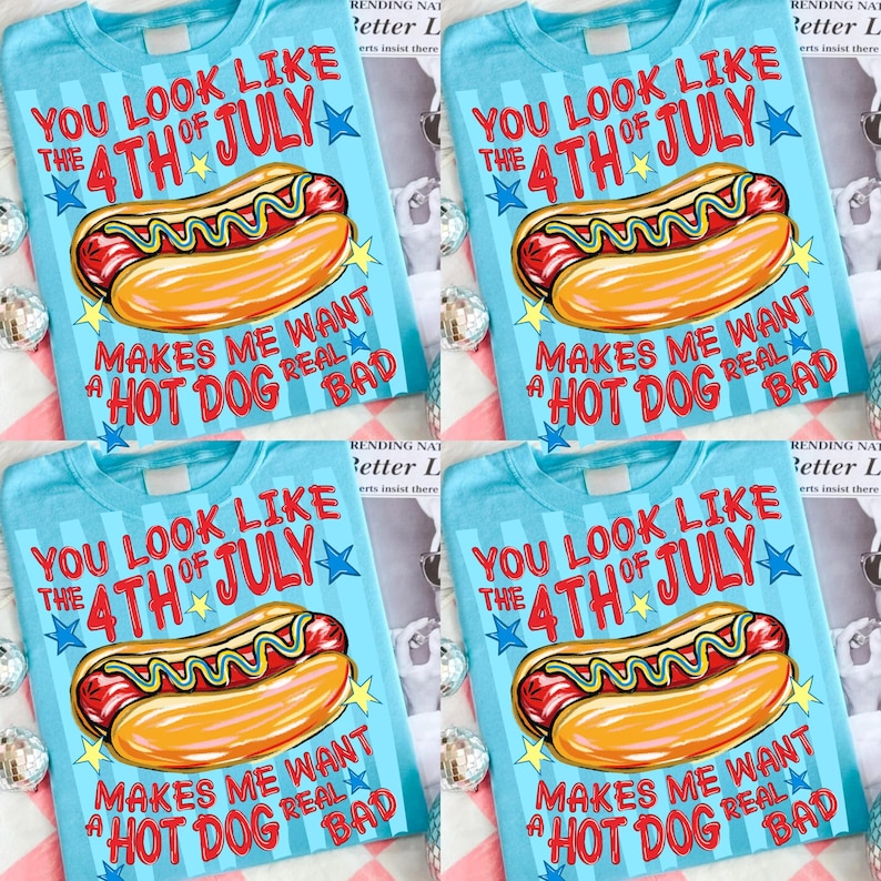 May include: Light blue t-shirts with a graphic of a hot dog and the text "YOU LOOK LIKE THE 4TH OF JULY MAKES ME WANT A HOT DOG REAL BAD". The design includes stars and a cartoon hot dog.
