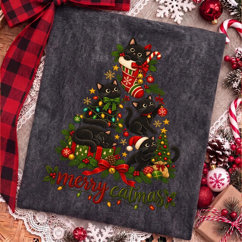 K&ouml;nnte beinhalten: Ein dunkelgraues T-Shirt mit einer Grafik aus schwarzen Katzen in Form eines Weihnachtsbaums, verziert mit Ornamenten, Lichtern und einem Weihnachtsstrumpf. Der Text "merry catmas" steht in roter und gr&uuml;ner Schrift unten.