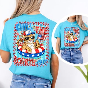 Op de afbeelding: Lichtblauw T-shirt met een afbeelding van een luipaard met een zonnebril en een patriottische hoed, drijvend in een rood, wit en blauw zwemband. De tekst "Chill the Fourth Out" wordt weergegeven in een golvend lettertype.