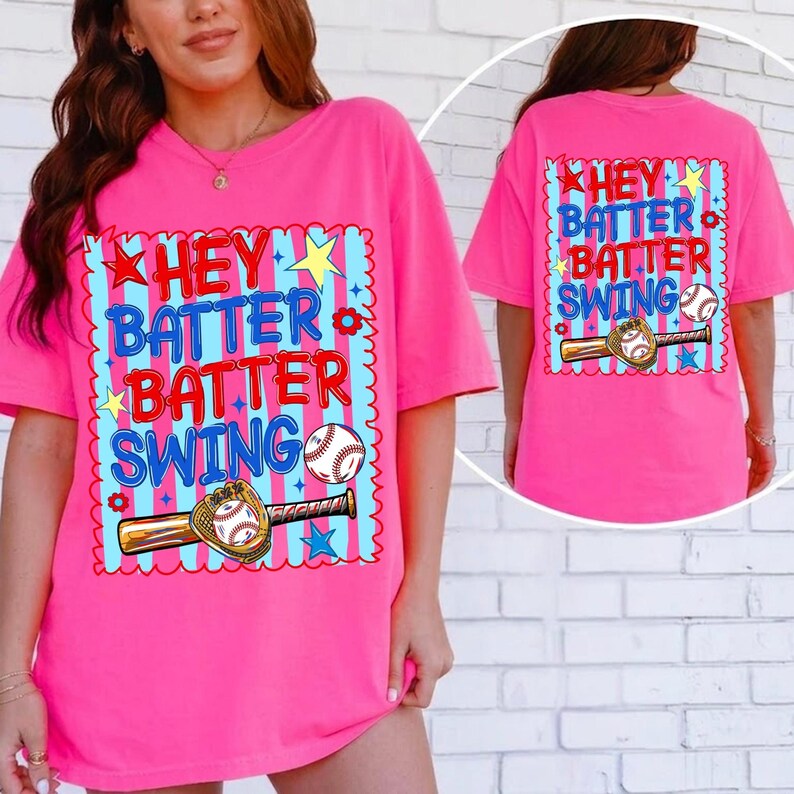 K&ouml;nnte beinhalten: Leuchtend pinkes T-Shirt mit dem Schriftzug "Hey Batter Batter Swing" in Blau und Rot, zusammen mit einer Baseball- und Schl&auml;gergrafik. Die R&uuml;ckseite des Shirts zeigt das gleiche Design. Das Shirt hat kurze &Auml;rmel und eine lockere Passform.