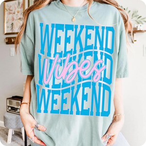 K&ouml;nnte beinhalten: Hellgr&uuml;nes T-Shirt mit dem Schriftzug "WEEKEND Vibes WEEKEND" in Blau und Rosa. Das Design ist &uuml;berlagert, mit dem Wort "Vibes" in Schreibschrift. Das T-Shirt hat einen Rundhalsausschnitt und kurze &Auml;rmel.
