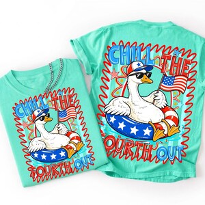 May include: Two turquoise t-shirts with a patriotic design. The graphic features a goose wearing sunglasses and a hat, floating in a red, white, and blue inner tube, holding an American flag. The text reads "Chill the Fourth Out."