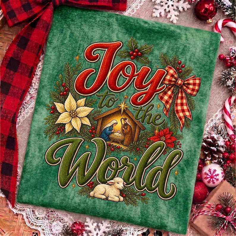 Może przedstawiać: Zielony panel z tkaniny z napisem Joy to the World czerwoną i zieloną czcionką. Wz&oacute;r przedstawia scenę narodzin w drewnianej stajence, białą gwiazdę betlejemską, czerwone jagody, gałązki sosny oraz małe białe jagnię u dołu obrazka.