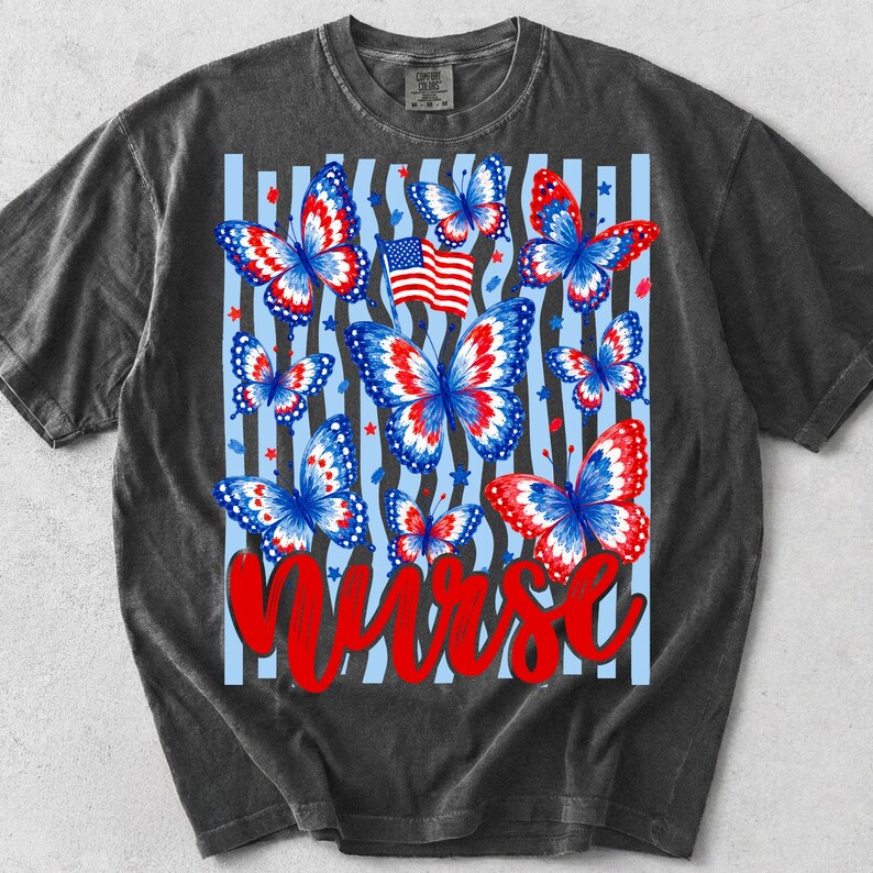 Peut inclure: Un t-shirt gris anthracite &agrave; manches courtes avec une impression graphique de plusieurs papillons aux motifs rouges, blancs et bleus. Le design comprend un petit drapeau am&eacute;ricain, des &eacute;toiles &eacute;parpill&eacute;es, des rayures verticales bleu clair et le mot Nurse en rouge.