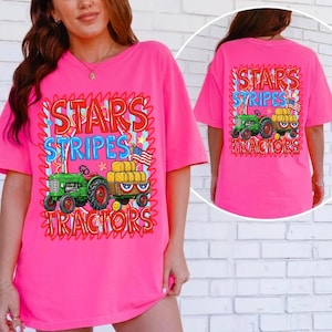 Pode incluir: Uma t-shirt rosa brilhante com um design gr&aacute;fico que apresenta um trator verde puxando uma carro&ccedil;a de feno, uma bandeira americana e as palavras "STARS, STRIPES, TRACTORS". A parte de tr&aacute;s da t-shirt tem o mesmo design.