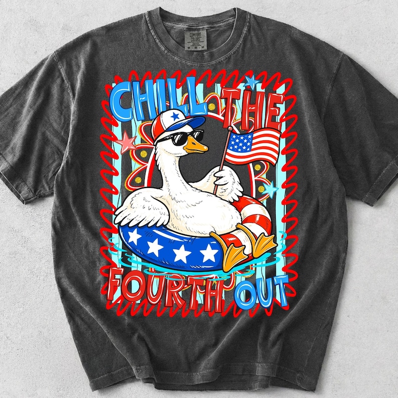 May include: Dark gray t-shirt featuring a cartoon goose wearing sunglasses and a patriotic hat, floating in a red, white, and blue inner tube. The shirt has the text "CHILL THE FOURTH OUT" in red and blue.