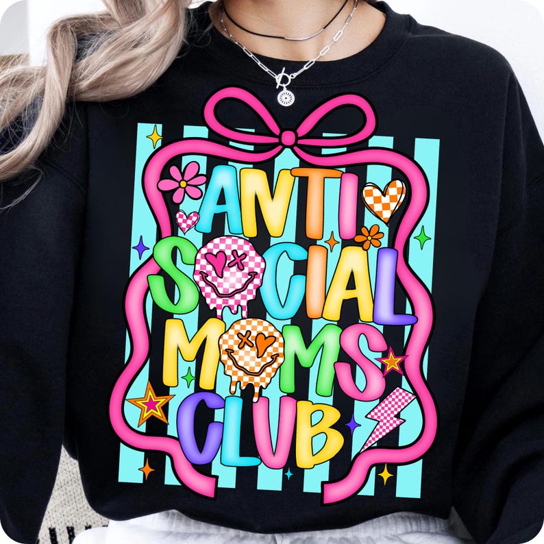 K&ouml;nnte beinhalten: Schwarzes Sweatshirt mit dem Text "ANTI SOCIAL MOMS CLUB" in einem farbenfrohen Design. Die Grafik enth&auml;lt ein rosa Band, Smiley-Gesichter, Blumen und einen Blitz, vor einem blau gestreiften Hintergrund.