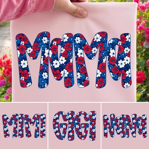 May include: A light pink fabric with the word "MAMA" in large, bold letters. The letters are filled with a floral pattern in red, white, and blue, resembling a patriotic design. Additional text below reads "MIMI", "GIGI", and "NANA".