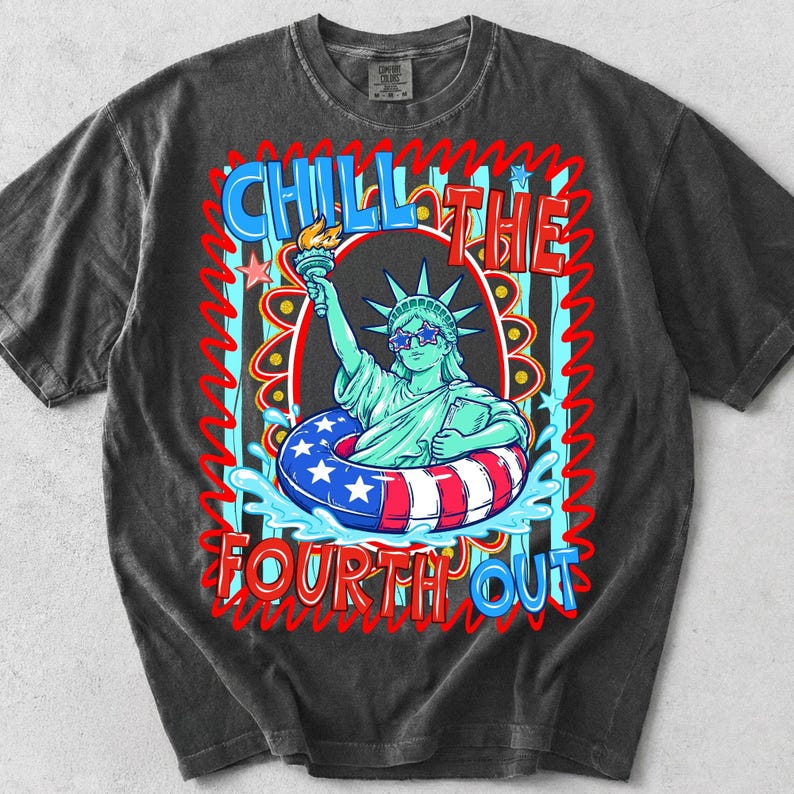 May include: Dark gray t-shirt featuring a graphic of the Statue of Liberty wearing sunglasses and a life preserver with red, white, and blue stripes and stars. The text "CHILL THE FOURTH OUT" is displayed in a colorful font.