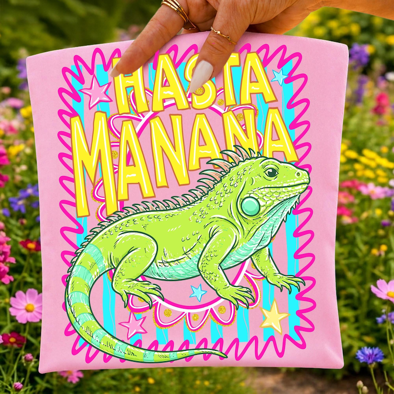 K&ouml;nnte beinhalten: Rosafarbenes T-Shirt mit einer Illustration einer gr&uuml;nen Leguan-Echse und dem gelben Text "HASTA MANANA". Das Design enth&auml;lt Sterne und einen wellenf&ouml;rmigen Rand. Der Leguan hat blaue und gelbe Akzente.