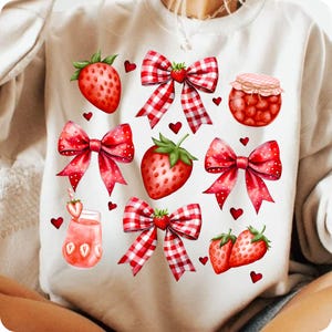 Könnte beinhalten: Weißer Pullover mit einer rot-weiß karierten Schleife, roten Erdbeeren und einem Glas Erdbeermarmelade. Das Design wiederholt sich auf dem gesamten Pullover.