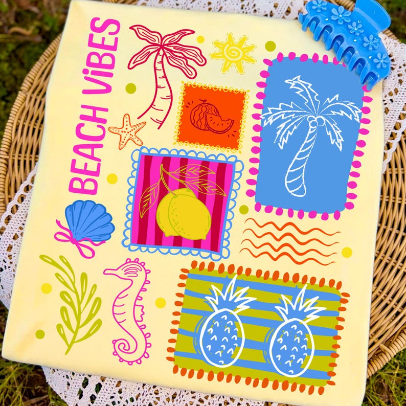 May include: A yellow beach towel with the words "BEACH VIBES" in pink. The towel features colourful illustrations of a palm tree, sun, seashell, seahorse, and pineapples. A blue hair clip is in the upper right corner.