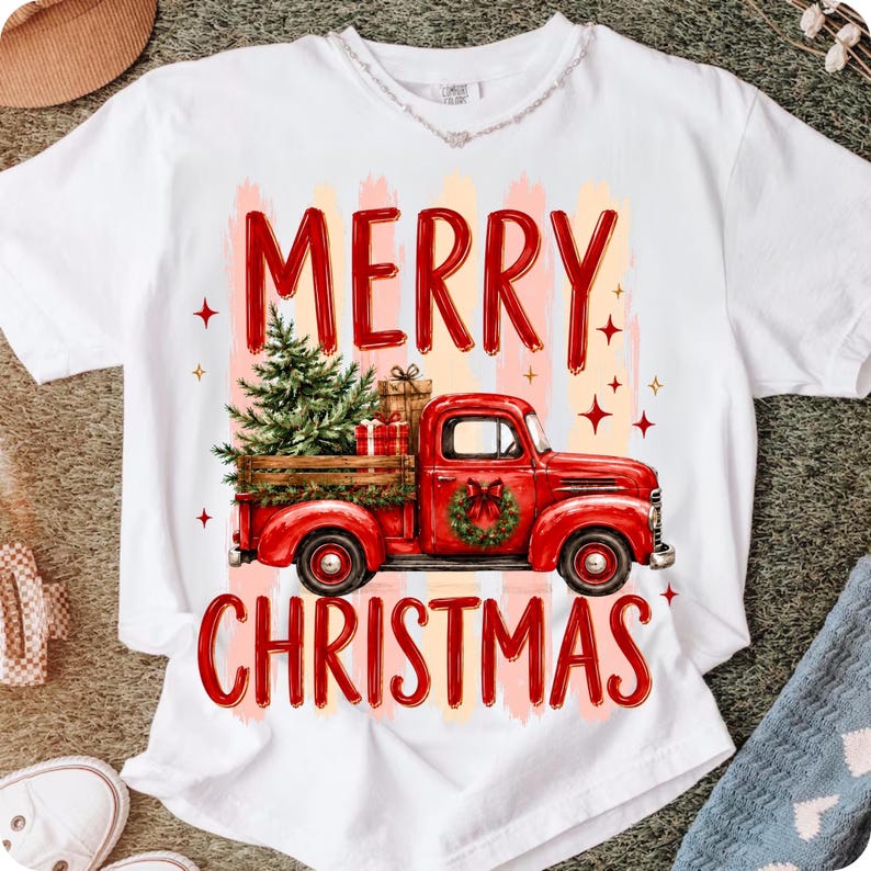 Może przedstawiać: Biały t-shirt z kr&oacute;tkim rękawem z grafiką czerwonej ciężar&oacute;wki w stylu vintage przewożącej choinkę i prezenty. Napis MERRY CHRISTMAS jest nadrukowany na czerwono nad i pod ciężar&oacute;wką, z akcentami w postaci małych czerwonych gwiazdek.