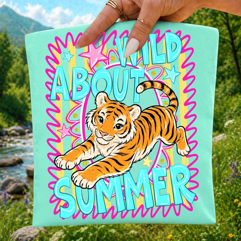K&ouml;nnte beinhalten: Eine hellt&uuml;rkisfarbene Tragetasche mit einem Zeichentricktiger mit orangefarbenen und schwarzen Streifen. Die Tasche zeigt die Worte "WILD ABOUT SUMMER" in einer verspielten Schriftart, umgeben von Sternen und wellenf&ouml;rmigen Linien.