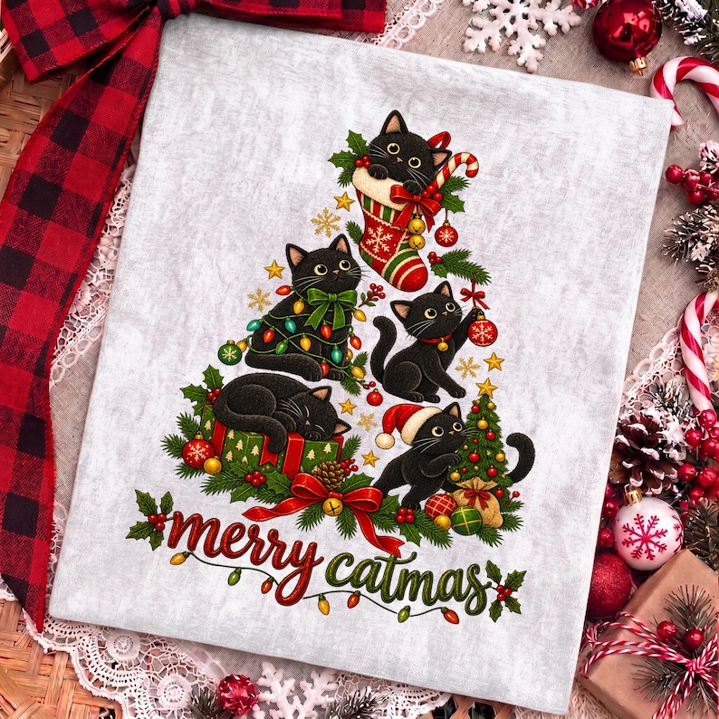 K&ouml;nnte beinhalten: Ein hellgrauer Stoff mit einer Grafik von f&uuml;nf schwarzen Katzen in Tannenbaumform, verziert mit Weihnachtskugeln, Lichterketten und einem Strumpf. Der Schriftzug "merry catmas" ist unten in roter und gr&uuml;ner Schrift mit kleinen Lichtern.