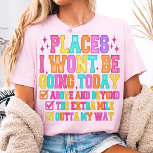 K&ouml;nnte beinhalten: Hellrosa T-Shirt mit dem bunten Schriftzug "PLACES I WON'T BE GOING TODAY". Darunter befinden sich drei Kontrollk&auml;stchen mit den Aufschriften "ABOVE AND BEYOND", "THE EXTRA MILE" und "OUTTA MY WAY".