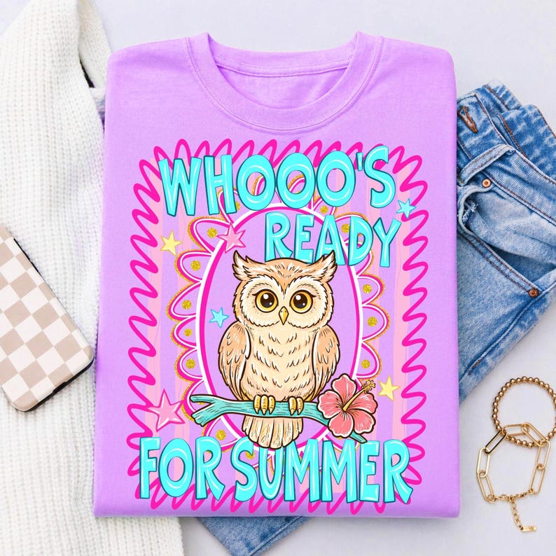 Peut inclure: T-shirt lilas avec un motif de hibou perch&eacute; sur une branche avec une fleur d'hibiscus. Le texte "WHOOO'S READY FOR SUMMER" est en turquoise, avec une bordure rose et jaune. Le t-shirt est pli&eacute;, avec un pull blanc, un jean et des accessoires en arri&egrave;re-plan.