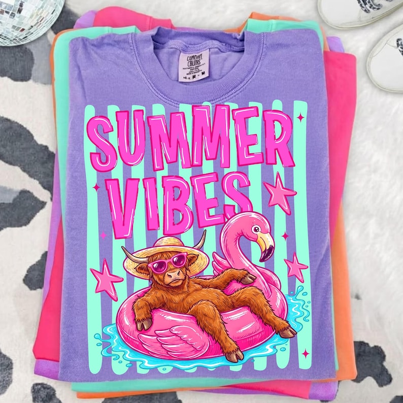 Highland Cow sublimation design applied to a white t-shirt, showcasing vibrant pink and teal colors