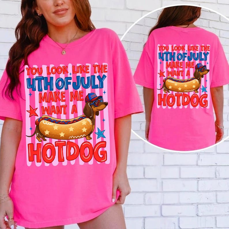 May include: A bright pink t-shirt with a graphic featuring a dachshund wearing sunglasses and a hat, designed as a hotdog. The text reads "YOU LOOK LIKE THE 4TH OF JULY MAKE ME WANT A HOTDOG" in red, white, and blue.