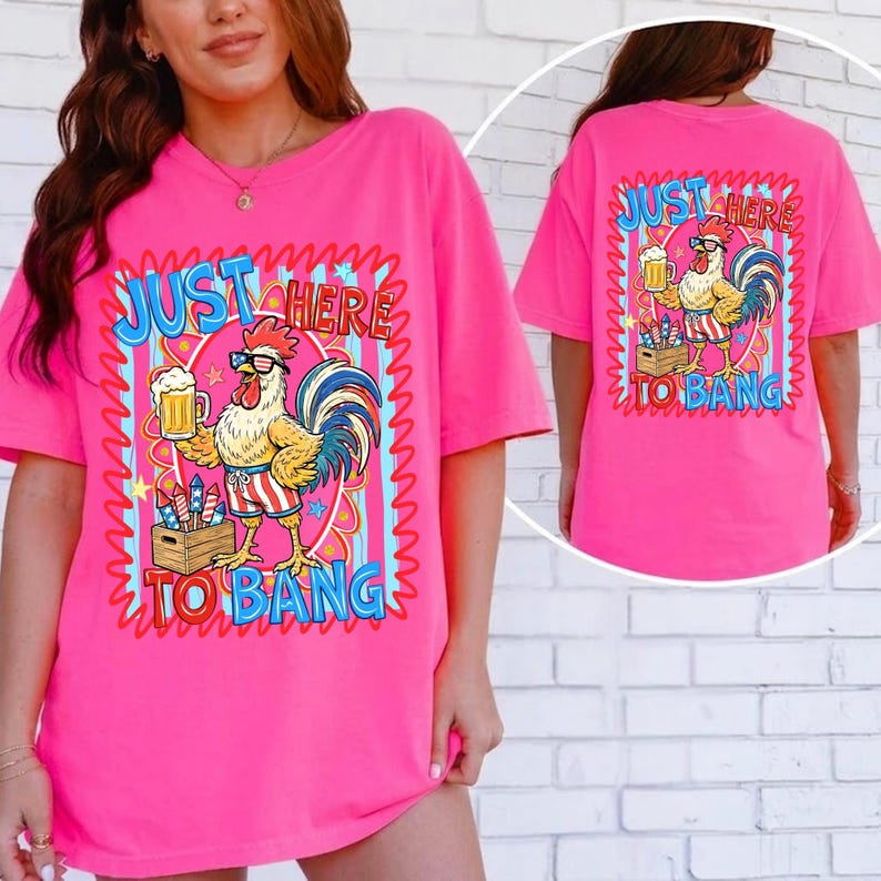 May include: A bright pink t-shirt with a graphic of a rooster wearing glasses, holding a beer, and fireworks. The text "JUST HERE TO BANG" is displayed in a wavy font. The shirt is a casual, oversized fit.