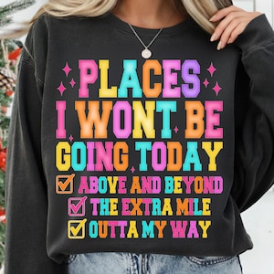 K&ouml;nnte beinhalten: Schwarzes Sweatshirt mit dem Text "PLACES I WONT BE GOING TODAY" in bunten Blockbuchstaben. Darunter befinden sich drei Kontrollk&auml;stchen mit den S&auml;tzen "ABOVE AND BEYOND", "THE EXTRA MILE" und "OUTTA MY WAY".