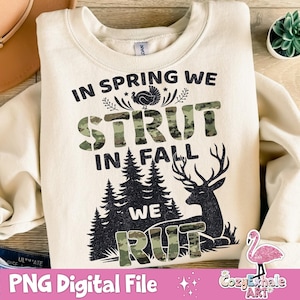 Könnte beinhalten: Cremefarbenes Sweatshirt mit dem Text "IN SPRING WE STRUT IN FALL WE RUT". Das Wort "STRUT" und "RUT" ist in einem Tarnmuster gehalten. Ein Truthahn, Bäume und ein Hirsch sind ebenfalls abgebildet. Der untere Teil des Bildes lautet "PNG Digital File".