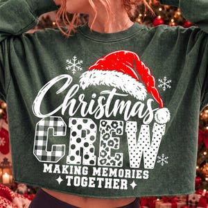 May include: A dark green crewneck sweatshirt featuring a graphic of a red Santa hat above the white text "Christmas CREW" with letters in plaid, polka dot, and leopard patterns. Below, the text reads "MAKING MEMORIES TOGETHER" with snowflakes.