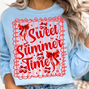 Pu&ograve; includere: Felpa azzurra con grafica rossa e rosa. La grafica presenta le parole "Sweet Summer Time" in rosso, insieme a fiocchi e ciliegie rosse. Il design &egrave; incorniciato da un bordo rosso smerlato.