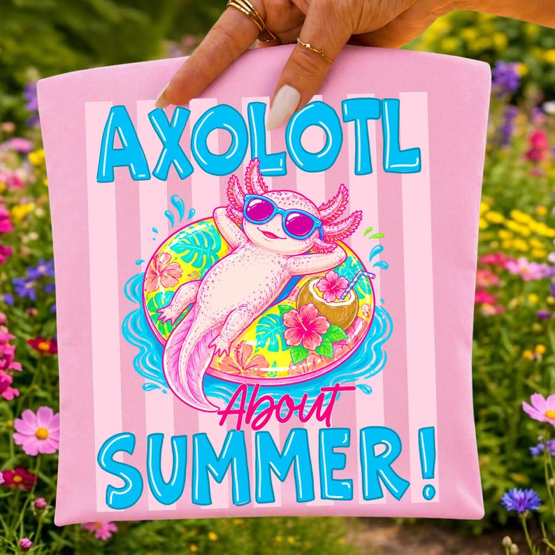 Peut inclure: Sac fourre-tout rose avec un axolotl de dessin anim&eacute; portant des lunettes de soleil et se relaxant sur une bou&eacute;e. Le texte "AXOLOTL About SUMMER!" est imprim&eacute; en bleu. Le fond a des rayures verticales.