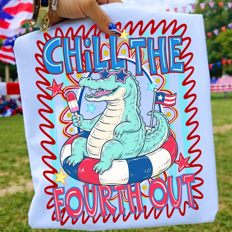 Puede incluir: Camiseta azul claro con tem&aacute;tica del 4 de julio. La camiseta presenta un cocodrilo de dibujos animados con gafas de sol en forma de estrella y flotando en una c&aacute;mara de aire roja, blanca y azul. El texto dice "Chill the Fourth Out."