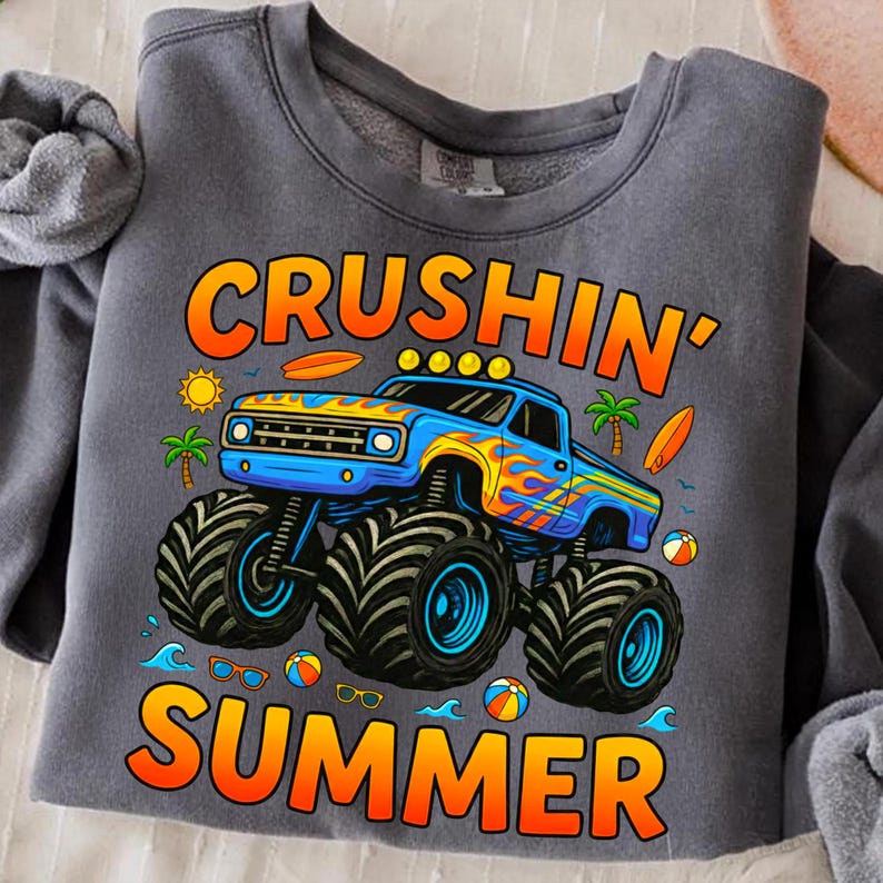 May include: Gray sweatshirt with a graphic of a blue monster truck with orange and yellow flames, the words "Crushin' Summer", a sun, palm trees, surfboards, and beach balls.