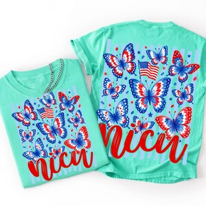 Peut inclure: Un t-shirt vert menthe avec un imprim&eacute; graphique de papillons rouges, blancs et bleus, de petites &eacute;toiles et un drapeau des &Eacute;tats-Unis. Le motif inclut le mot "nicu" en &eacute;criture cursive rouge sur un fond compos&eacute; de rayures bleu clair.