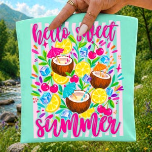 May include: A light mint green fabric pouch featuring a pink striped background and the text "hello sweet summer" in bright pink script. The design includes illustrations of three coconuts, yellow lemon slices, red cherries, and blue ice cubes.