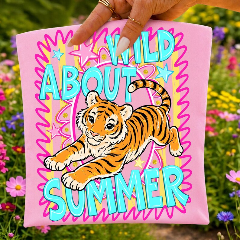 K&ouml;nnte beinhalten: Rosa Tragetasche mit einer Cartoon-Tiger-Illustration und den Worten "WILD ABOUT SUMMER" in T&uuml;rkis. Das Design umfasst Sterne und Wellenlinien in Gelb und Rosa. Der Tiger ist orange und schwarz.