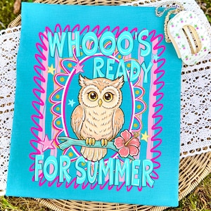 Peut inclure: Une serviette d&eacute;corative rectangulaire turquoise avec le texte "WHOOO'S READY FOR SUMMER" et un dessin de hibou perch&eacute; sur une branche avec une fleur d'hibiscus rose. Le design comprend des accents roses et jaunes.
