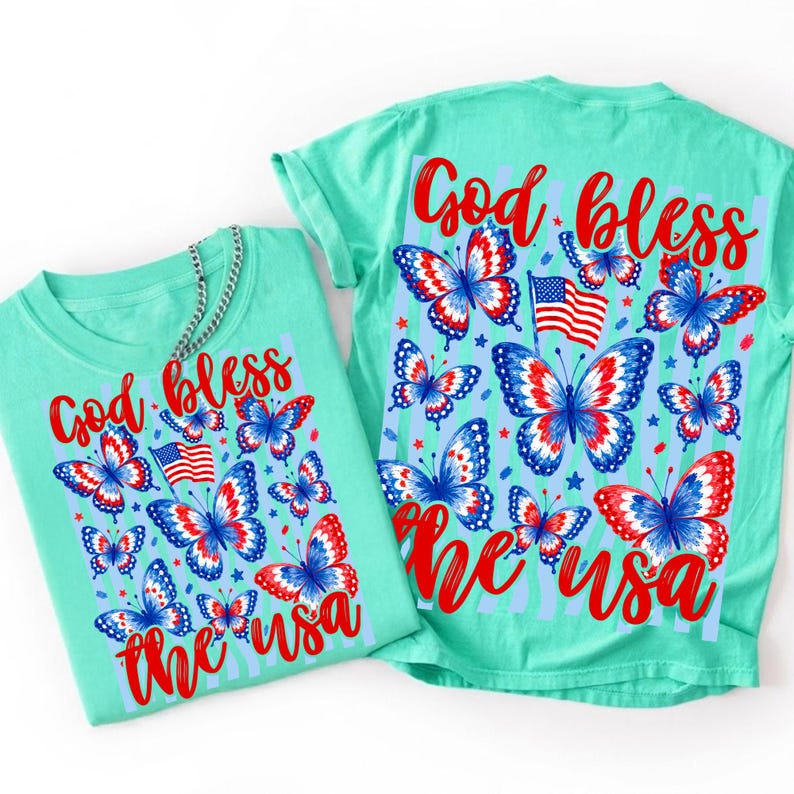 K&ouml;nnte beinhalten: Ein hellgr&uuml;nes T-Shirt mit einem Grafikdruck aus roten, wei&szlig;en und blauen Schmetterlingen, einer amerikanischen Flagge und dem roten Text "God bless the USA". Das Design ist auf der Vorder- und R&uuml;ckseite des Kleidungsst&uuml;cks zu sehen, mit einer silbernen Kette.