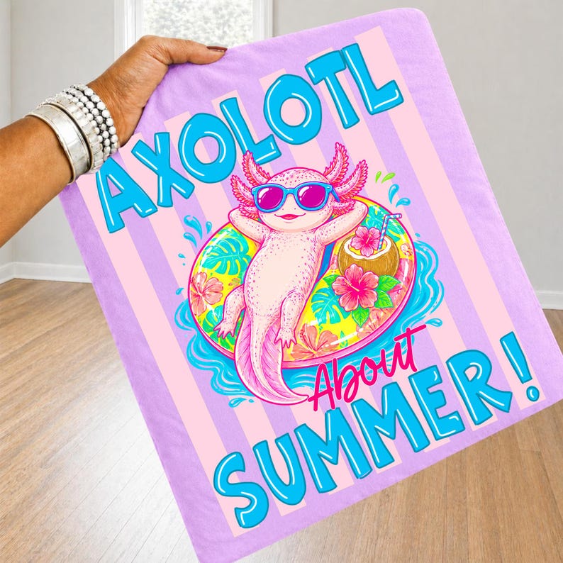 Peut inclure: Une couverture lilas avec un axolotl de dessin anim&eacute; portant des lunettes de soleil et se relaxant sur un flotteur. La couverture porte les mots "AXOLOTL About SUMMER!" en bleu et rose.