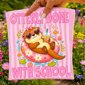 K&ouml;nnte beinhalten: Rosa Tragetasche mit dem Text "OTTERLY DONE WITH SCHOOL". Die Tasche zeigt einen Cartoon-Otter mit herzf&ouml;rmiger Sonnenbrille, der auf einem floralen Schwimmring schwimmt und ein Getr&auml;nk h&auml;lt. Der Hintergrund hat rosa Streifen und florale Akzente.