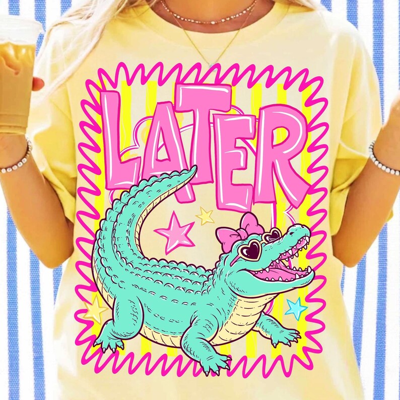 Close-up of the Later Gator design showcasing the stylized teal alligator with heart-shaped sunglasses and a coquette bow, highlighting the dithered edges.