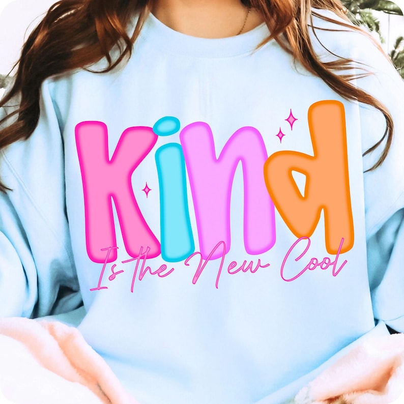 A vibrant mockup featuring the 'Kind Is The New Cool' PNG design applied to various items like a t-shirt, mug, and phone case.