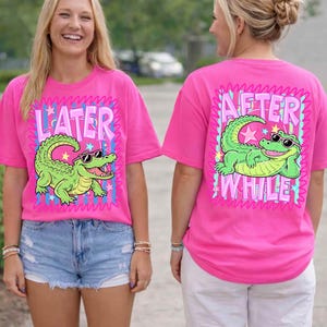 May include: Bright pink t-shirts with a cartoon alligator wearing sunglasses. One shirt says "LATER" and the other says "AFTER WHILE". The alligator is green with a white belly and is surrounded by a pink and blue design.