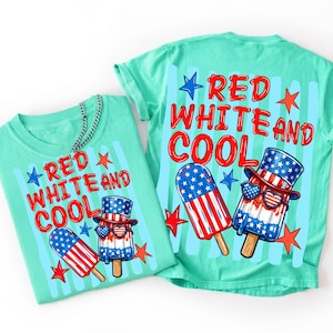 Peut inclure: Deux t-shirts vert menthe avec le texte "RED WHITE AND COOL" et un motif de glace &agrave; l'eau rouge, blanc et bleu. Une glace porte un chapeau patriotique et des lunettes de soleil en forme de c&oelig;ur. &Eacute;toiles et rayures compl&egrave;tent le design.