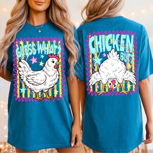 May include: Teal t-shirt with a cartoon chicken graphic. The front of the shirt says "GUESS WHAT?" with a drawing of a chicken. The back of the shirt says "CHICKEN BUTT" with a drawing of a chicken's rear end.
