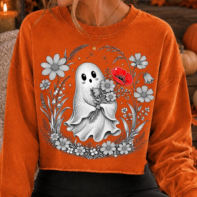 K&ouml;nnte beinhalten: Ein orangefarbenes Langarm-Sweatshirt mit einer zentralen Grafik eines wei&szlig;en Geistes, der einen Blumenstrau&szlig; h&auml;lt. Das Design zeigt schwarz-wei&szlig;e Strichzeichnungen von Blumen um den Geist herum, inklusive einer roten Mohnblume.