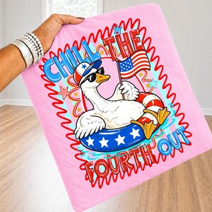 May include: Pink blanket with a cartoon goose wearing sunglasses, a patriotic hat, and an inner tube. The goose holds an American flag. Text reads "Chill the Fourth Out" in red and blue.