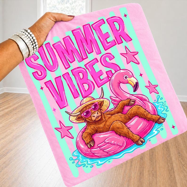 Może przedstawiać: R&oacute;żowy koc z napisem "SUMMER VIBES" w jasnor&oacute;żowym kolorze. Koc przedstawia kresk&oacute;wkową ilustrację brązowej krowy w okularach przeciwsłonecznych i słomkowym kapeluszu, relaksującej się na r&oacute;żowym pływaku w kształcie flaminga. R&oacute;żowe gwiazdki i turkusowe paski dopełniają projekt.