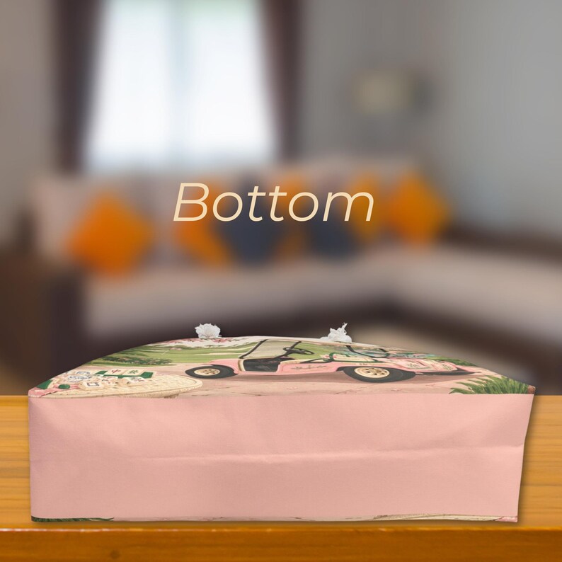 May include: A rectangular bag bottom with a light pink base color. The surface features a printed graphic of a pink golf cart on a green course with mahjong tiles in the foreground. The word Bottom is printed in white text above the bag.