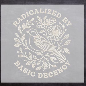 May include: A light-colored graphic design on a gray background features a bird perched on a floral branch. The text "RADICALIZED BY BASIC DECENCY" is arched above and below the bird illustration. The design is simple and elegant.